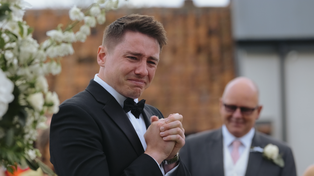 Emotional groom during wedding ceremony at The Little Green Wedding Barn captured by a Norfolk wedding videographer
