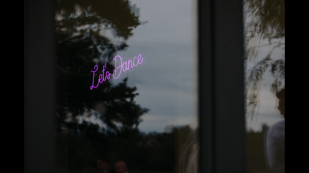 'Let's Dance' neon sign at The Little Green Wedding Barn captured by a Norfolk wedding videographer