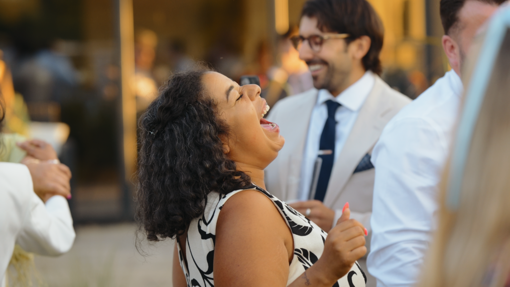 Guests dancing outside The Little Green Wedding Barn at golden hour captured by a Norfolk wedding videographer