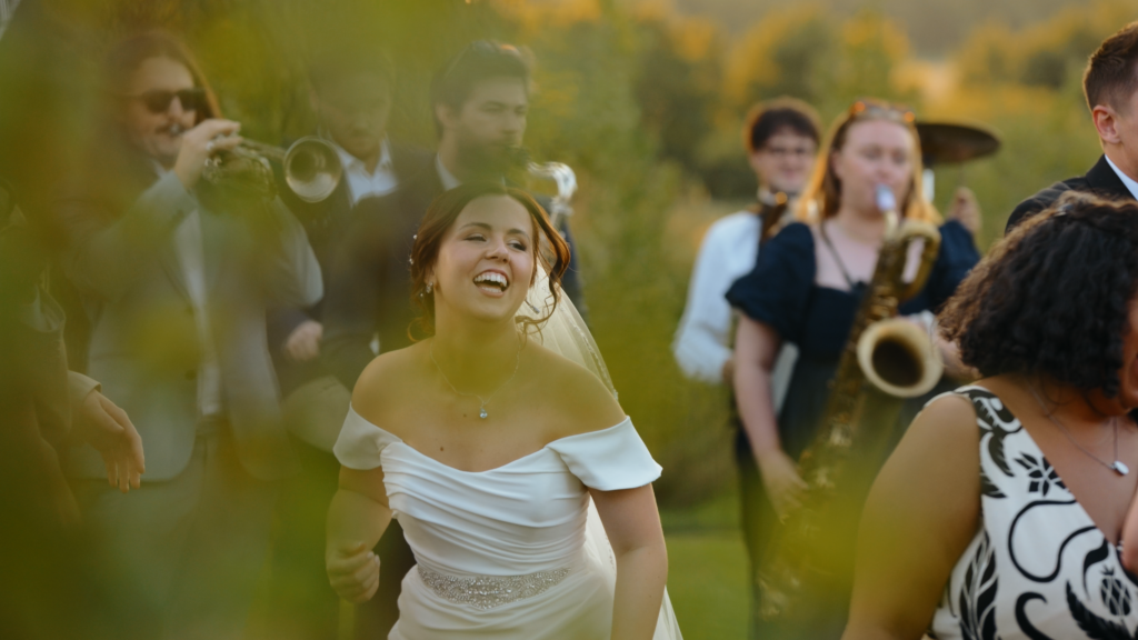 Guests dancing outside The Little Green Wedding Barn at golden hour captured by a Norfolk wedding videographer