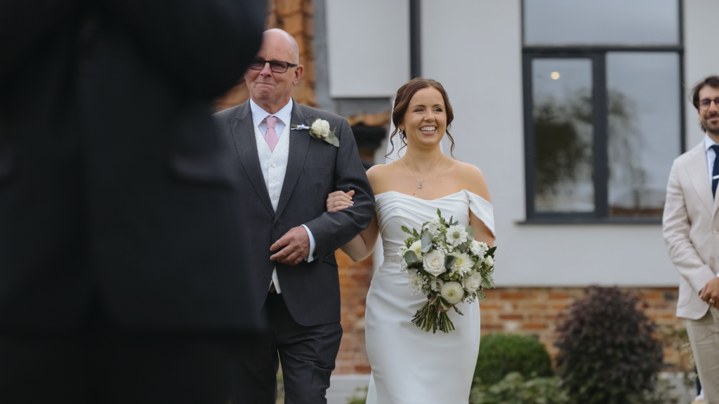 Bride walking down the aisle at The Little Green Wedding Barn captured by a Norfolk wedding videographer