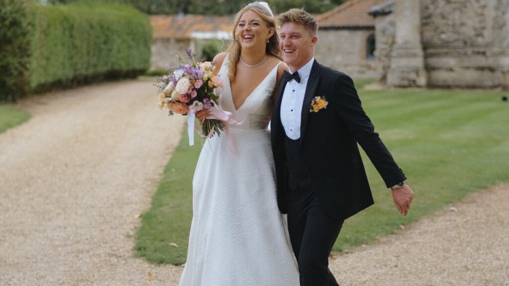 Bride and groom laughing together outside pentney abbey gates
