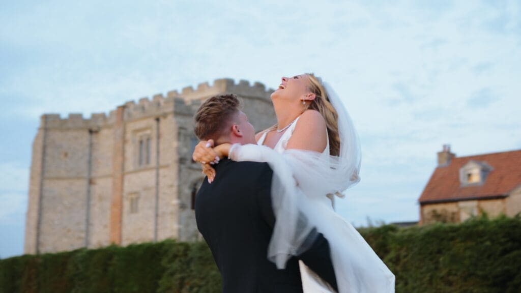 bride and groom spin at golden hour outside pentney abbey