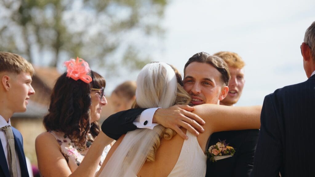Guest hugging bride at pentney abbey wedding reception