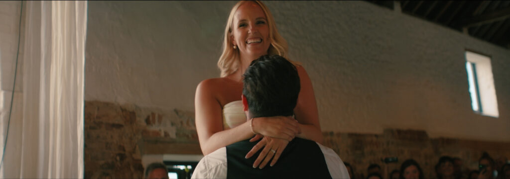 groom lifting bride up on dancefloor for first dance at curds hall barn in norfolk