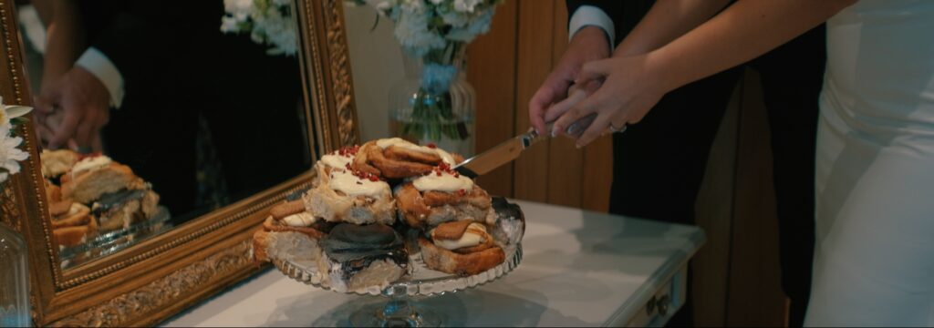 Bride and groom cut cake at Reymerston Hall Norfolk Wedding